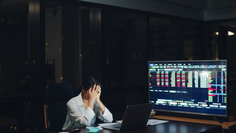 Investor reacts to stock market volatility while monitoring global financial data on trading screens