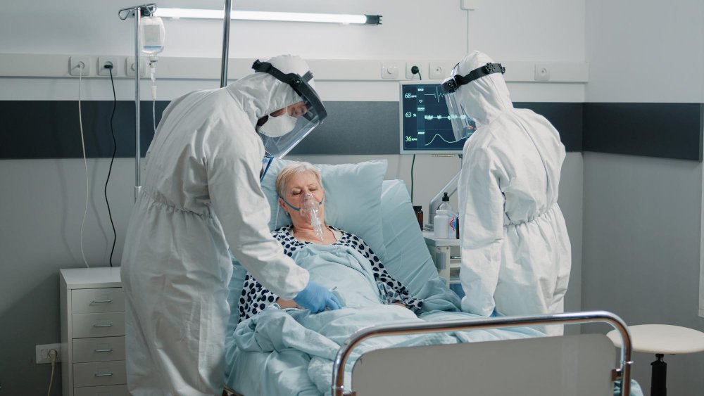 Medical staff in protective gear treating a hospital patient during a meningitis outbreak